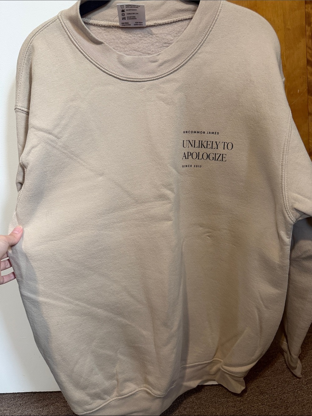 Uncommon James Beige Pullover Sweatshirt with 'Unlikely To Apologize' Text
